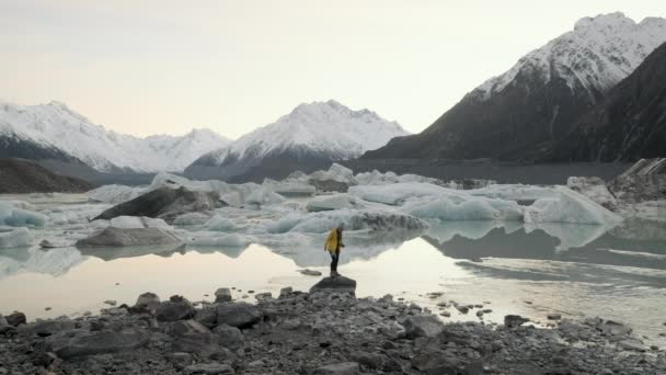 站在新西兰塔斯曼湖中央的妇女 在寒冷的冬夜 冰封的湖面被白雪覆盖着 — 图库视频影像