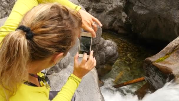 Kobieta Trzyma Aparat Robiąc Zdjęcia Malowniczego Wodospadu — Wideo stockowe