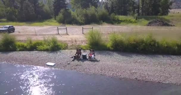 Drönare Hyperlapse Två Killar Som Sitter Campingstolar Vid Floden — Stockvideo