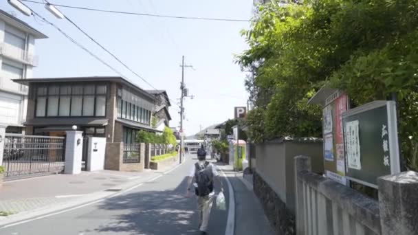 バッグを手に日本の静かな通りを歩くアジアの高齢者 — ストック動画