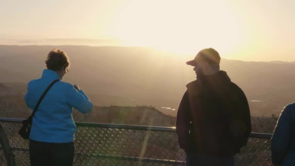 석양을 배경으로 천천히 플레어 브라이스 구경하는 관광객들 — 비디오