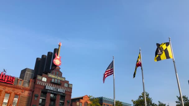 美国国旗在天空中飘扬的慢镜头 巴尔的摩内港的硬岩咖啡店就在后面 — 图库视频影像