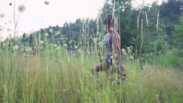 一个嬉皮士女孩在花草丛中漫步的慢镜头 — 图库视频影像