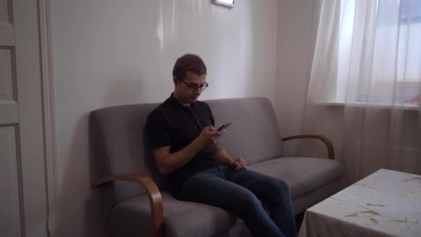 Junge Erwachsene Sitzen Auf Couch Wohnzimmer Und Schreiben Sms — Stockvideo