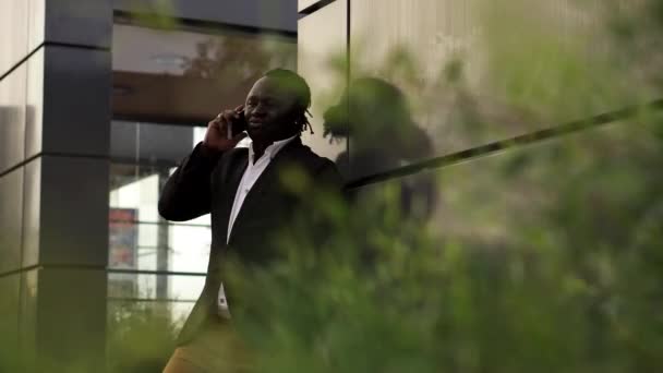 Wideo Afrykańskiego Biznesmena Garniturze Opierającego Się Ścianę Budynku Odbierającego Telefon — Wideo stockowe