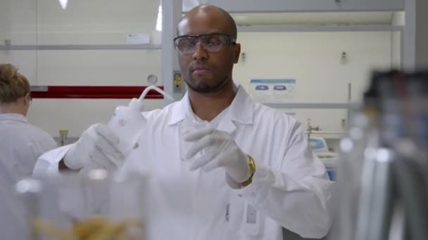 Hombre Químico Laboratorio Investigador Masculino Agregando Líquido Una Botella Vidrio — Vídeos de Stock