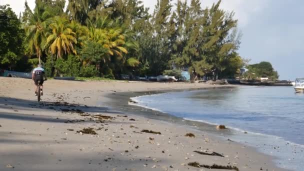 Hombre Bicicleta Playa Junto Laguna Rodeada Cocoteros — Vídeos de Stock