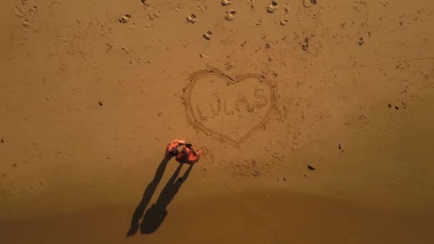 Aerial Zooming Out Padre Hijo Dibujando Amor Corazón Arena Playa — Vídeo de stock