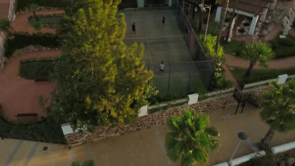 Aerial Panning Auf Tennisspieler Spielen Tennis Außerhalb Des Luxuriösen Resorts — Stockvideo