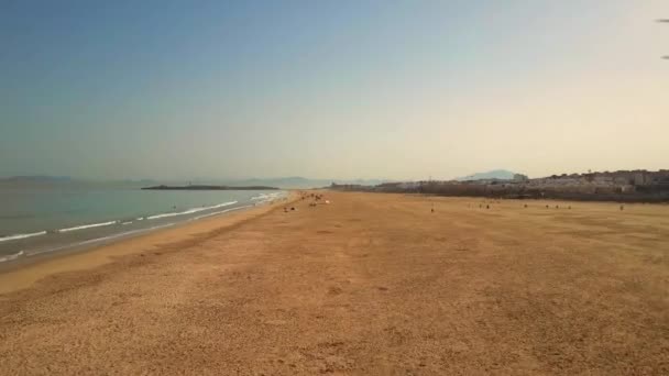 Aerial Avançar Sunbathers Deitado Praia Areia Com Cidade Europeia Direita — Vídeo de Stock