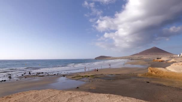 Люди Прогуливаются Пляжу Эль Медано Background Beautiful Sky Montaa Roja — стоковое видео