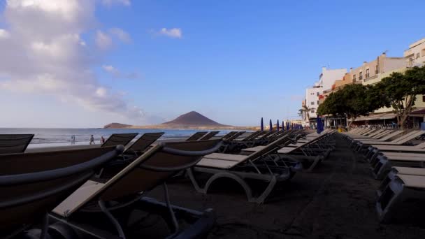 Uitzicht Lege Ligbedden Medano Beach Terwijl Sommige Mensen Hun Ochtendwandeling — Stockvideo