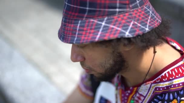 Seorang Pemuda Etnis Melihat Lihat Sekeliling Sambil Mengenakan Pakaian Jalanan — Stok Video