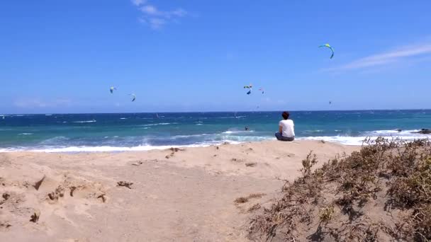 Kobieta Siedząca Patrząca Windsurferów Kitesurferów Skał Napisami Edycja Zwolnionym Tempie — Wideo stockowe