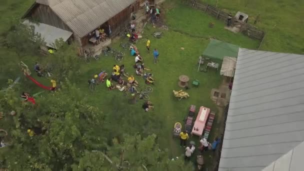 罗马尼亚农村自行车比赛中 骑自行车和骑自行车的人在乡间房屋外休息的空中景象 — 图库视频影像