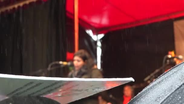 抗议者用抗议标志和雨伞挡雨 而活动人士则在背后发表演说 — 图库视频影像