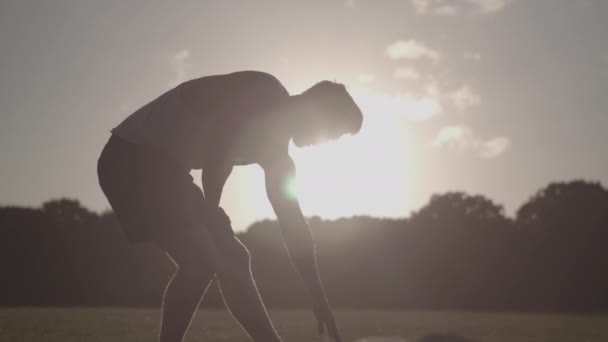 Hombre Estirando Sus Piernas Antes Una Carrera Mientras Silueta Por — Vídeos de Stock