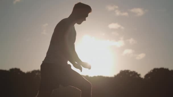 Mand Strækker Benene Før Løb Mens Bliver Silhouetted Aften Solen – Stock-video
