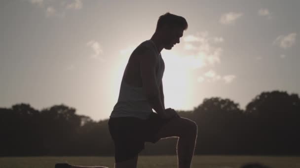 Man Strekt Zijn Benen Het Park Voordat Hij Gaat Hardlopen — Stockvideo