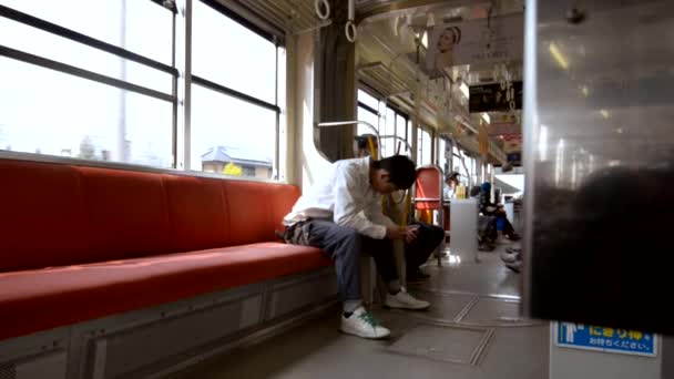 Junger Japaner Telefoniert Öffentlichen Verkehrsmitteln Blick Auf Sein Handy Während — Stockvideo