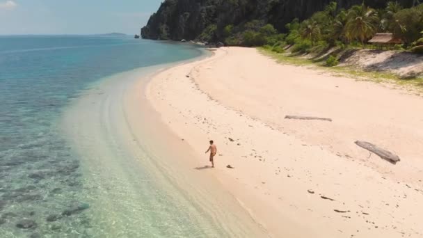 Lotnicza Orbita Drona Strzał Wokoło Facet Chodzi Pięknej Tropikalnej Plaży — Wideo stockowe