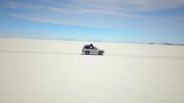 Aerial Tracking Drone Shot Car Driving White Salt Desert Uyuni — Wideo stockowe