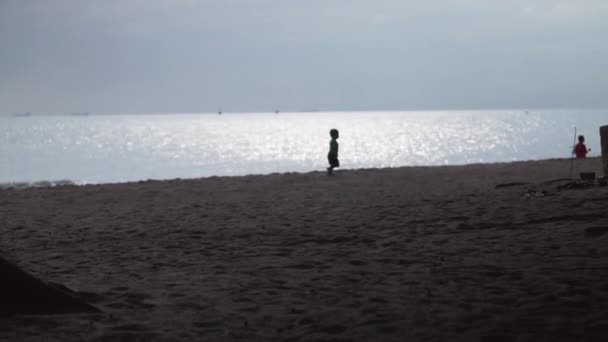 Силуэт Маленького Ребенка Бегущего Пляжу Солнечном Отражающем Морском Фоне — стоковое видео