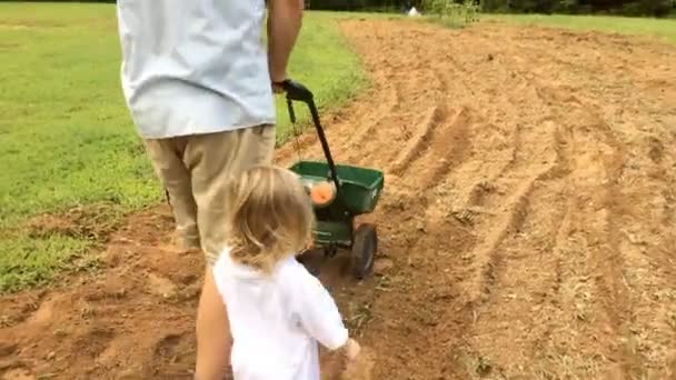Father and daughter working in garden together outdoors