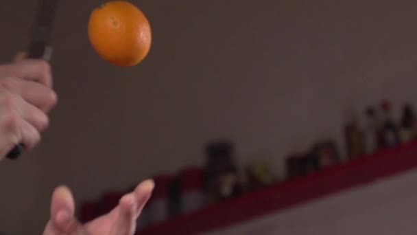空気中でオレンジを切る鋭いナイフのスローモーションショットフルーツ忍者スタイル — ストック動画