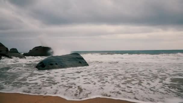 在蓝海的阴天 慢流的海水在海滨岩石上飞溅 — 图库视频影像