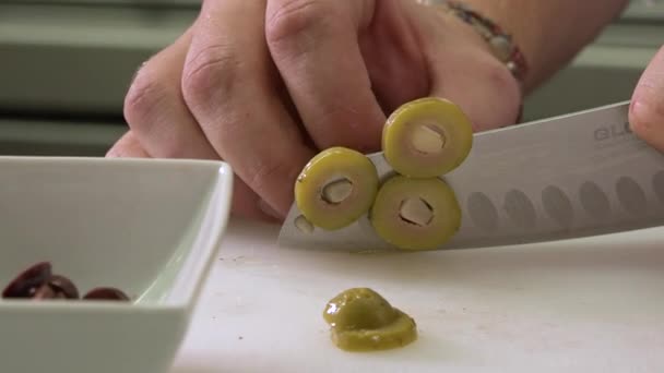 Onze Chef Snijdt Groene Olijven Legt Een Witte Kom Schietpartij — Stockvideo