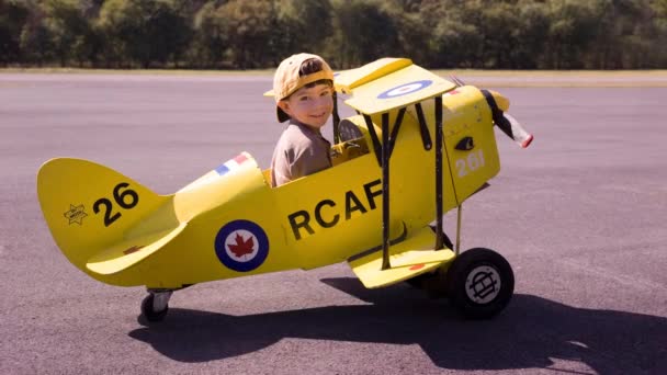 Cinemagraph Boy Toy Biplane Tarmac Forest Background — Vídeo de stock