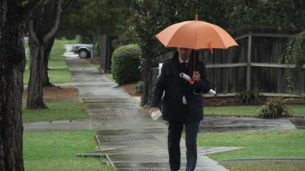 Middle Aged Man Walking Rain Orange Umbrella Slow Motion — Stockvideo