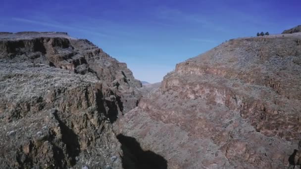 底に川と道路がある砂漠の高い峡谷の劇的な空中 ドローンショット — ストック動画