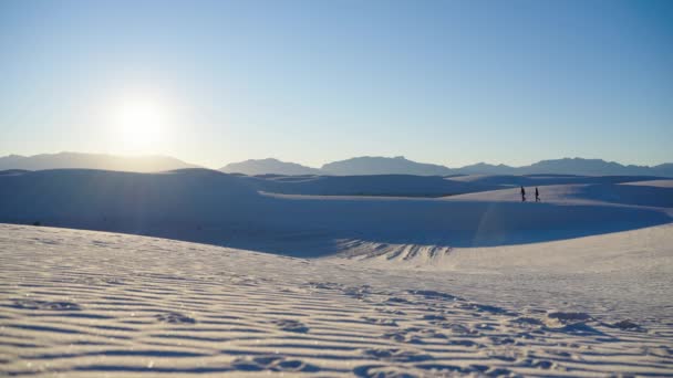 Два Человека Идут Песчаной Дюне Пустыни Закатом Горами — стоковое видео