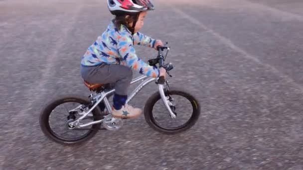 Handheld Shot Young Boy Riding His Bike Empty Car Park — Vídeo de Stock