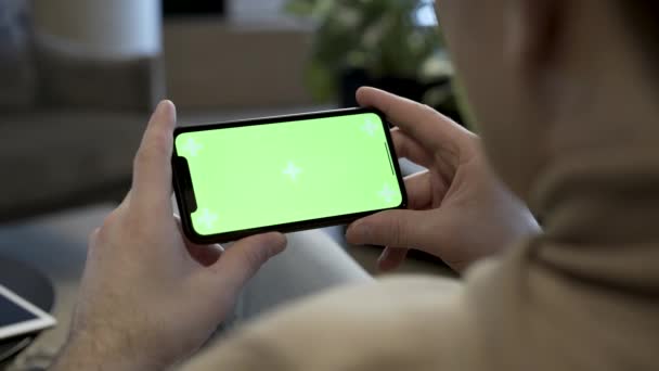 Молодой Человек Держит Мобильный Смартфон Пальцами Ландшафтном Положении Смотрит Экран — стоковое видео