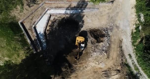 在偏远地区建筑工地施工的挖掘机卡车在自然环境中建造住宅区的黄鹤洞俯视图 — 图库视频影像