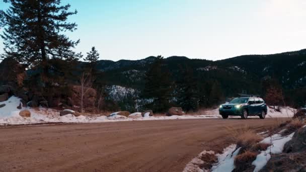 Stunning Tracking Shot Blue Suv Driving Snowy Dirt Mountain Road — Vídeos de Stock