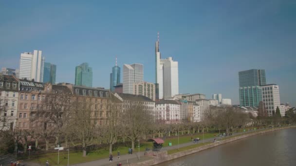 在阳光明媚的日子里 法兰克福的天际线是主要的摩天大楼 主要的河流是主要的 河岸上有人民 — 图库视频影像