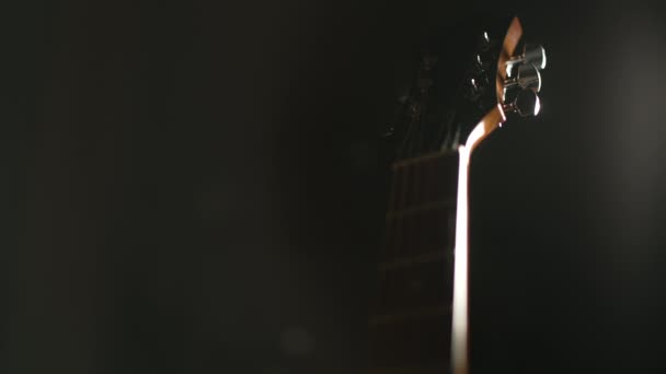 Ręka Sięga Ramy Aby Podnieść Gitarę Akustyczną Tylne Światło Ciemność — Wideo stockowe