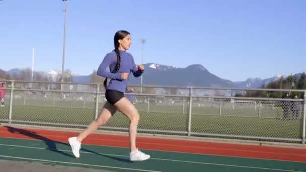 Athletic Latina Woman Jogging Outdoor Track Wide Follow Shot — Stockvideo