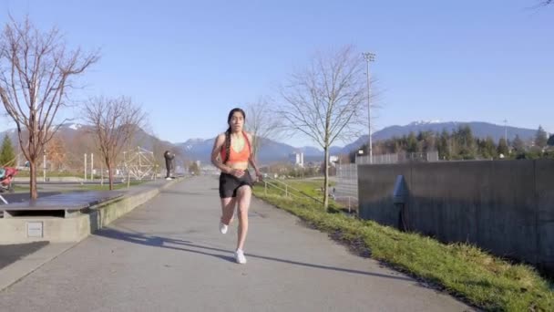 拉丁短跑运动员在橙色运动服中用手抓住膝盖吸气 — 图库视频影像