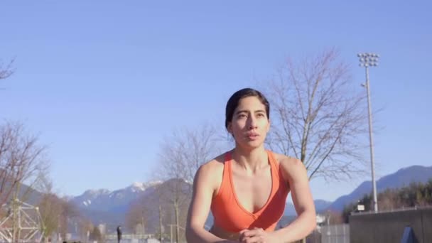 穿上衣服 女人坐在瑜伽旁边 冲着雪板摆出姿势 站起身来 — 图库视频影像