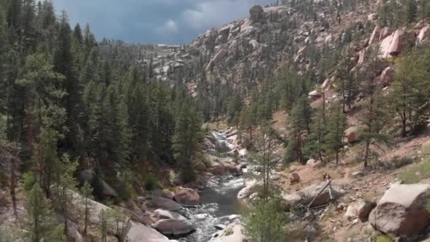 Shallow River Runs Rugged Rocky Mountain Valley Aerial — Vídeo de Stock