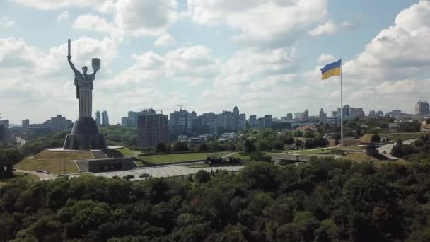 4K曇った夏の日に巨大なウクライナの旗と祖国の記念碑と永遠の炎の空中映像 ドローン映像はキエフ洞窟ラブラに向かって行きます — ストック動画