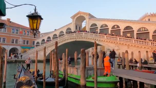 在意大利威尼斯的贡多拉 里阿托桥 Ponte Rialto 与游客一道 在日落时分出发游览贡多拉 慢动作 — 图库视频影像