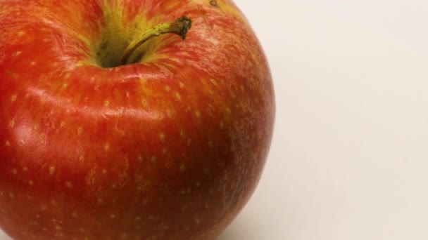 4Kの白い表面の背景に回転する赤いリンゴのマクロショット — ストック動画