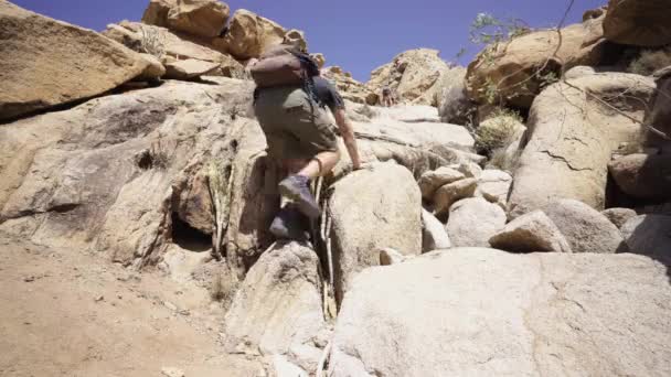 若い白人バックパッキング冒険家カナリア島の岩の山を登る スペイン旅行休暇のトレッキング先 撮影を見上げ広い角度 — ストック動画