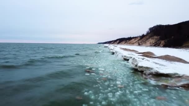 4K drone flies along frozen shoreline